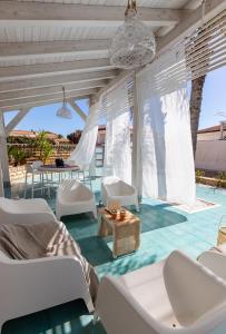 d'une terrasse avec des chaises blanches et une table. dans l'établissement SICILY SUN CON ACCESSO SPIAGGIA, à Santa Maria Del Focallo