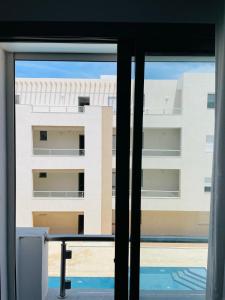 una ventana con vistas a un edificio en Luxus-Apartment mit Poolblick, en Kelibia