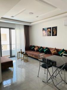 sala de estar con sofá y mesa en Luxus-Apartment mit Poolblick en Kelibia