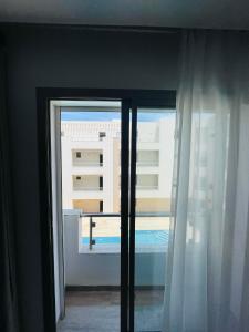 a room with a window with a view of a building at Luxus-Apartment mit Poolblick in Kelibia
