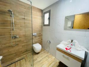a bathroom with a shower and a toilet and a sink at Luxus-Apartment mit Poolblick in Kelibia