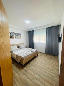 1 dormitorio con 1 cama y suelo de madera en Luxus-Apartment mit Poolblick en Kelibia