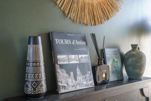 a shelf with some books and vases on it at La Petite Plume - PrestiPlace Tours in Tours