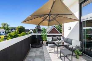 a patio with a table and an umbrella at CozyQuarter: Suite mit Workstation - Nähe: Bonn & Flughafen in Siegburg