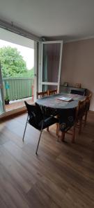a dining room with a table and chairs and a balcony at Appartement Grand Paris in Saint-Denis