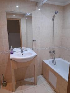 a bathroom with a sink and a bath tub at Negresko Family Apartment in Elenite