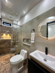 uma casa de banho com um WC, um lavatório e um espelho. em HOTEL TORRE DELUXE ¨SANTORINI¨ em Doradal