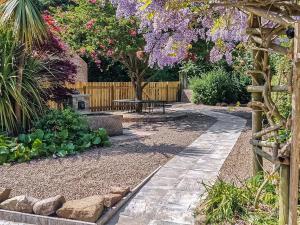 a garden with a fence and purple wisteria at West End Lodge in Barmston