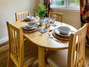 a wooden table with plates and glasses on it at Castle Park in Ceres