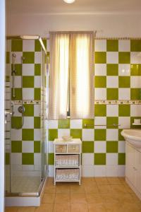 La salle de bains est pourvue d'un mur en damier vert et blanc. dans l'établissement SICILY SUN CON ACCESSO SPIAGGIA, à Santa Maria Del Focallo