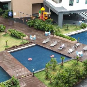 a swimming pool with a playground in a building at Private Condo Port Dickson Waterfront in Port Dickson