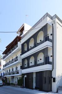 ein Apartmenthaus mit einer schwarz-weißen Fassade in der Unterkunft Uphill Unique Boutique Suites in Skiathos-Stadt