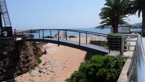 un pont sur une plage de sable avec une plage dans l'établissement Playa de la palmera, à Candás