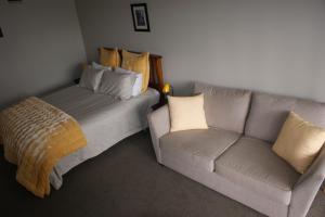 a living room with a couch and a bed at 73 Milton Accommodation in Cambridge