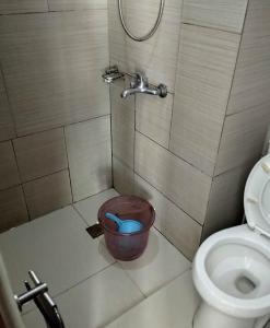 a bathroom with a shower with a bucket next to a toilet at Alabang Staycation in Manila