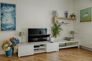 ein Wohnzimmer mit einem TV in einem weißen Unterhaltungszentrum in der Unterkunft Apartamenty MM - Chmielna in Zielona Góra