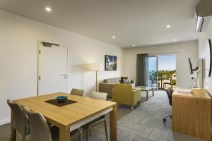 a dining room and living room with a table and chairs at Quest Townsville on Eyre in Townsville