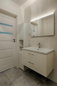 a white bathroom with a sink and a mirror at Apartamenty MM - Chmielna in Zielona Góra