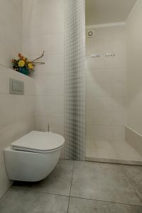 een witte badkamer met een toilet en een douche bij Apartamenty MM - Chmielna in Zielona Góra