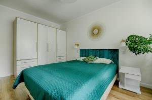 1 dormitorio con 1 cama azul y armario blanco en Apartamenty MM - Chmielna, en Zielona Góra