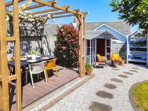 a patio with a table and a wooden pergola at Harbour Heights in Brixham