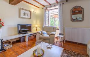 a living room with a tv and a chair and a table at Amazing Home In Douzillac With 4 Bedrooms And Outdoor Swimming Pool in Douzillac