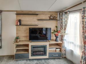 uma sala de estar com televisão e lareira em Long View Lodge em Felton