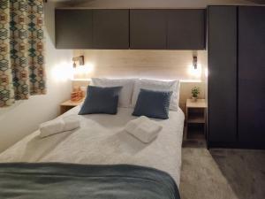 um quarto com uma grande cama branca com almofadas azuis em Long View Lodge em Felton