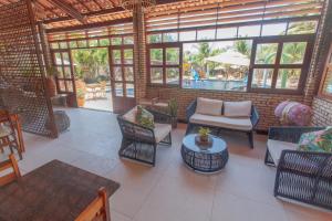 un patio con sillas, mesas y una piscina en Hotel Jangadas, en Águas Belas