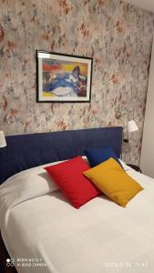 Una cama con dos almohadas de colores encima. en IL BALCONE SUL LAGO, en Magreglio