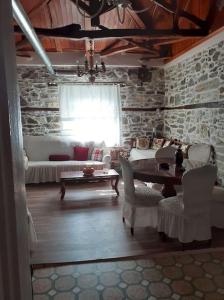 salon ze stołem, krzesłami i kanapą w obiekcie Ξυλοπετρα / Wood & stone house w mieście Tsagarada