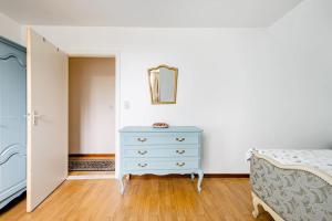 een slaapkamer met een blauwe dressoir en een spiegel bij Private Room in a beautiful Villa in Gent