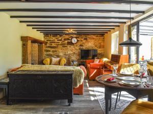 ein Wohnzimmer mit einem Sofa und einem Tisch in der Unterkunft Willow Tree Cottage in Hayle