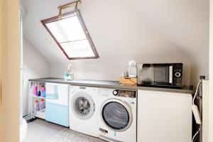 a laundry room with a washing machine and a microwave at Private Room in a beautiful Villa in Ghent