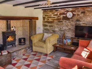 ein Wohnzimmer mit einem Sofa und einem Kamin in der Unterkunft Willow Tree Cottage in Hayle
