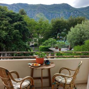 einen Tisch und Stühle auf einem Balkon mit Bergblick in der Unterkunft Apartment Navigator's lodging in Kotor
