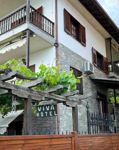 una valla de madera frente a un edificio con un cartel en Viva Properties, en Ouranoupoli