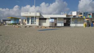 un edificio en la playa junto a una playa de arena en Les 2 dauphins en Le Barcarès