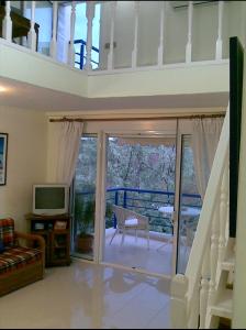 een woonkamer met een balkon met een glazen schuifdeur bij RELAXING SUMMER HOUSE HANIOTI in Hanioti