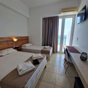 um quarto de hotel com duas camas e uma varanda em Edelweiss em Tsoútsouros
