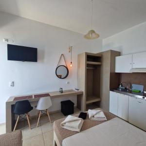 ein Wohnzimmer mit einem Bett und einem Tisch sowie eine Küche in der Unterkunft Edelweiss in Tsoútsouros