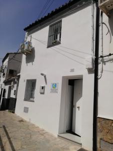 un edificio blanco con puerta y ventana en La Casita de Ubrique, en Ubrique