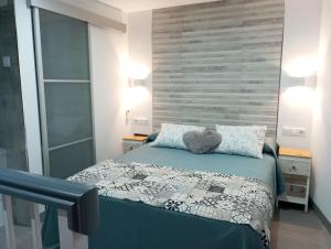 a bedroom with a bed and a wooden wall at La Casita de Ubrique in Ubrique