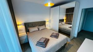 ein Schlafzimmer mit einem Bett, auf dem zwei Handtücher liegen in der Unterkunft Home by the Lake nr 8 in Sibiu