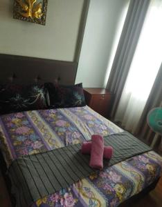 een bed met een paar roze sokken erop bij Staycation Alabang in Manilla