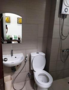 een badkamer met een toilet en een wastafel bij Staycation Alabang in Manilla