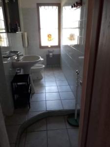 La salle de bains est pourvue d'un lavabo, de toilettes et d'une fenêtre. dans l'établissement Vacanze in Sardegna a Posada, à San Giovanni