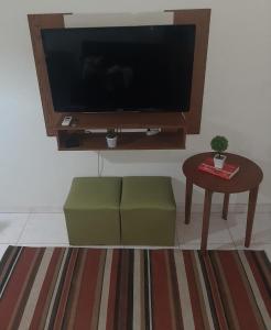 een woonkamer met een televisie en een salontafel bij Estúdio na quadra da praia in Rio de Janeiro