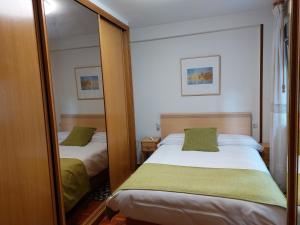 a bedroom with two beds and a mirror at El Trébol in Oviedo