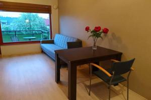 a living room with a table and a couch and roses at Aisahome in Pärnu
